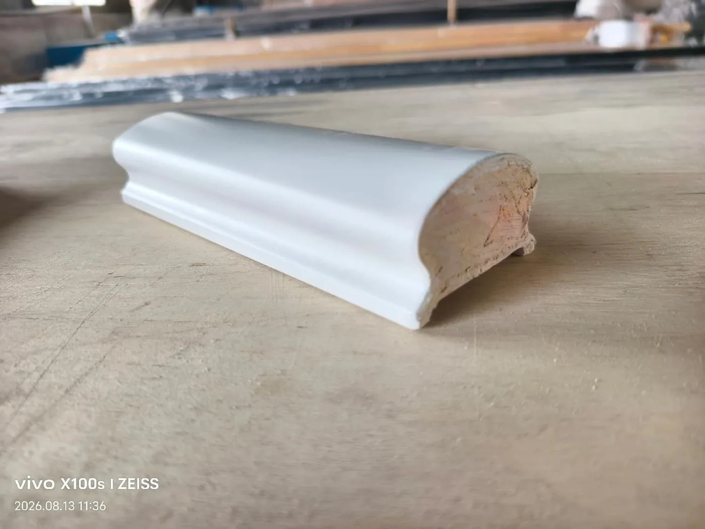 White coated solid wood handrail profile on a work surface